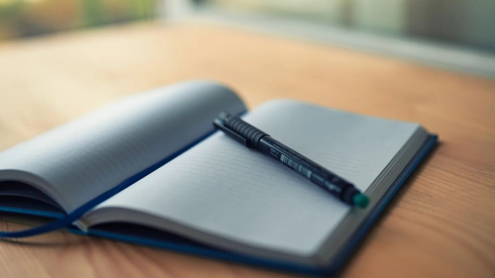 Open lined notebook with a pen
