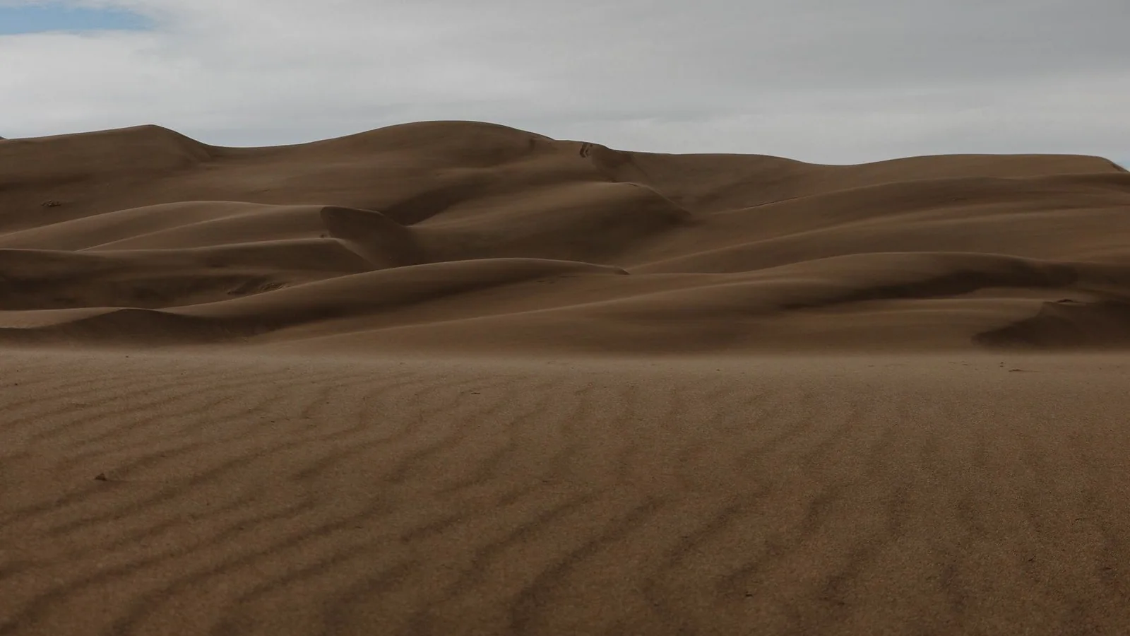 Desert dunes beneath clouds
