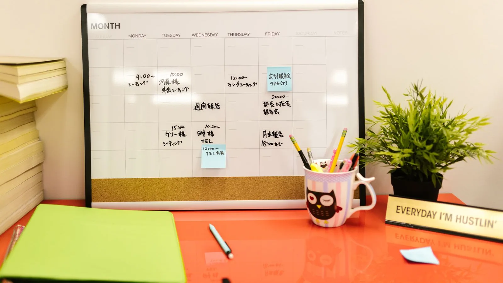 Calendar and stationery on an orange desk